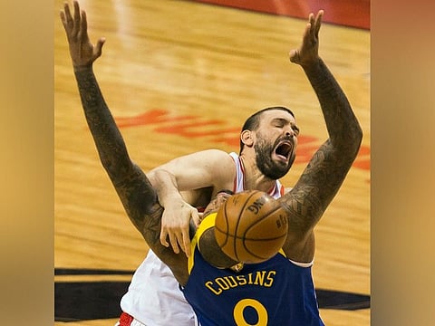 Toronto Raptors center Marc Gasol, top, loses control of the ball under pressure from Golden State Warriors centrer DeMarcus Cousins (0) during first-half basketball action in Game 5 of the NBA Finals in Toronto, Monday, June 10, 2019. (AP)