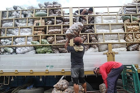 BENGUET. Porters load a variety of vegetables from the Benguet Agri-Pinoy Trading Center (BAPTC) to be delivered in various market outlets in the country. (Photo by Jean Nicole Cortes)