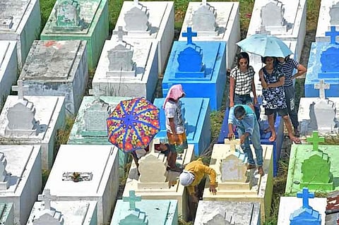 Two men quickly cleaned a tomb inside the Roman Catholic Cemetery in Davao City due to the hot weather while waiting for the concerned relatives to finish the repainting.
