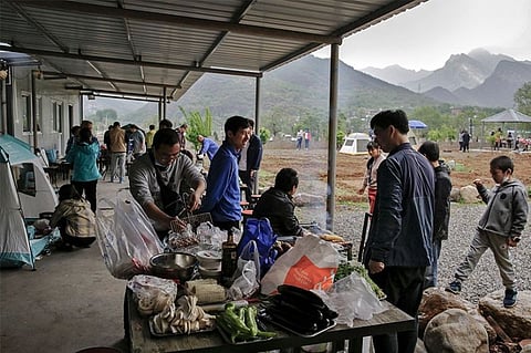 CHINA. People gather for a barbecue at a scenic area in Fangshan district in Beijing, Monday, May 4, 2020, after authorities loosened up nationwide restrictions following months of lockdown over the new coronavirus outbreak. (AP photo)