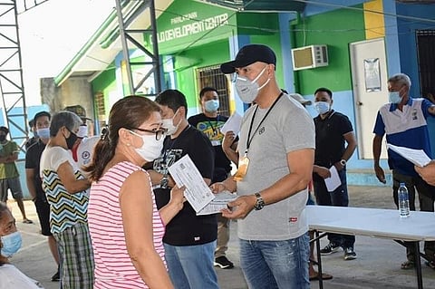 PAMPANGA. Mabalacat City Mayor Crisostomo Garbo distributes food coupons to non-recipients of the national government's Social Amelioration Program in Barangay Poblacion. (Contributed photo)
