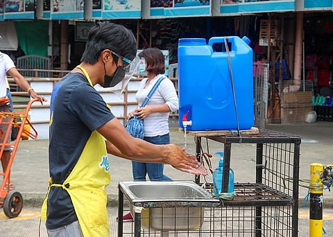 SIMPLE AND EFFECTIVE. A man washes his hands at the Baguio City Public Market. Experts continue to remind the public that proper hand washing is the best way to prevent Covid-19. (Jean Nicole Cortes)