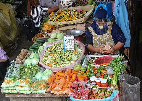 STAYING AFLOAT. Market vendors comply with the minimum health standards while continuing their business amid the pandemic. Vendors say they are still struggling to generate income due to lesser foot traffic inside the Baguio City Public Market. (Photo by Jean Nicole Cortes)