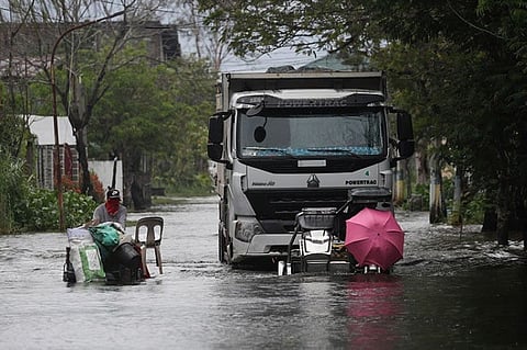 PAMPANGA. Motorists with an umbrella negotiate a flooded road due to Typhoon Quinta (Molave) in Pampanga province on Monday, October 26, 2020. (AP)