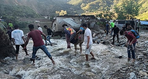 NEPAL. People wade past a flooded area in Dipayal Silgadhi, Nepal, Thursday, October 21, 2021. (AP)