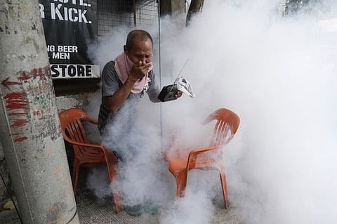 MANILA. In this photo taken in March 2021, a resident holds his nose and portable radio as he tries to avoid the disinfectants used on their village as a precaution against the spread of Covid-19 in Metro Manila. (File)