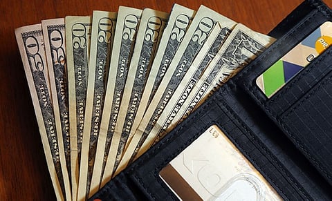 INFLATION. Cash is fanned out from a wallet. Inflation is still so high that despite pay raises many workers have received, Americans' purchasing power is eroding. / AP