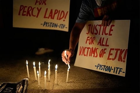 MANILA. Activists hold a candle beside slogans as they condemn the killing of Filipino journalist Percival Mabasa during a rally in Quezon City, Philippines on Tuesday, October 4, 2022. (AP)