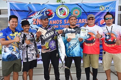 WINNING CATCH. James Babor (4th from left) of Aquahookers Club from Tanjay City raises the 6.9-kilogram yellow fin tuna which won him P15,000 in the Jigging Category of the 2nd San Carlos Vamos Fishing Tournament, July 8-9. (San Carlos Photo)