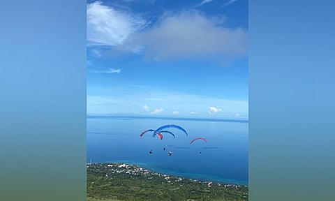 GLIDING HEAVEN. In this photo posted on the Facebook page of Oslob, Cebu Paragliding on July 10, 2023, tourists are seen paragliding above the southern Cebu town. The Commission on Audit has reported in its Annual Audit Report that the local government unit has registered P230 million in tourism revenue in 2022. / OSLOB, CEBU PARAGLIDING