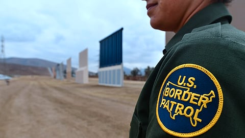US Border Patrol officer Tekae Michael stands near prototypes of US President Donald Trump's proposed border wall on November 1, 2017 in San Diego, California. 
The concrete and steel structures, erected in a remote area in San Diego, will be tested for 30 to 60 days to determine which design meets the needs to secure the border, US Customs and Border Patrol Protection said in a statement. Authorities said that in considering the mockups -- built by six companies from across the United States -- they will evaluate a number of characteristics including anti-breaching, anti-climbing and anti-digging capabilities. / AFP PHOTO / FREDERIC J. BROWN        (Photo credit should read FREDERIC J. BROWN/AFP/Getty Images)