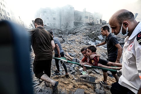 Two boys were pulled out of the rubble after Israeli warplanes targeted Yarmouk Square in Jalaa Street, Gaza City on October 25, 2023.