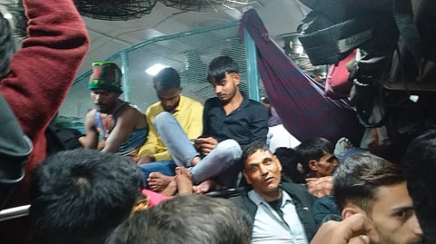 ट्रेन के अंदर इतने यात्री हैं कि खड़े टिकट जांच अधिकारी के घुसने भर की भी जगह नहीं है।  