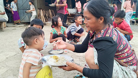 मणिपुर के चुराचांदपुर जिले के रेंकाई स्कूल में बनाए गए एक राहत शिविर में एक कुकी महिला अपने बच्चे को खाना खिलाते हुए.