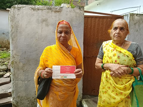 बैंक पासबुक दिखाती गैस पीड़ित विधवाएं 