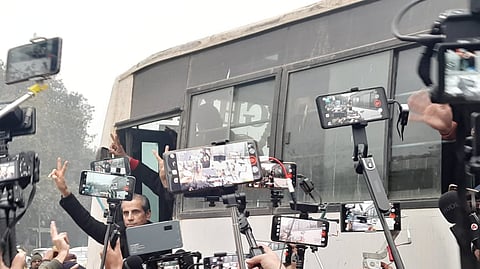 Advocate Mehmood Pracha waves to media persons as he boards the police bus to be detained