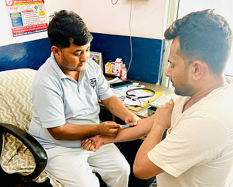 A tribal youth giving his blood sample to be sent to Rajasthan Education Minister Madan Dilawar.