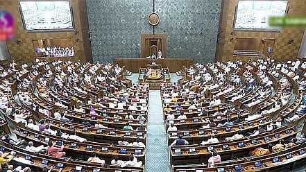 Aerial view of the Lok Sabha in session from behind the hall. MPs are seated in semi-circular rows raised like an amphitheatre. At the centre in front is the speaker.