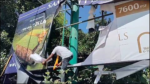 KRV protestors tearing a billboard