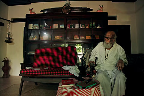 Dalit Bandhu in front of his bookshelf with his many books