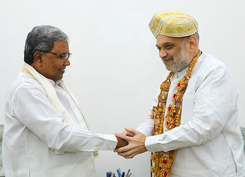 Siddaramaiah and Amit Shah shaking hands