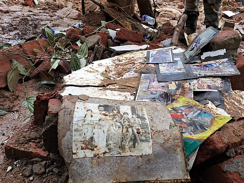 Pictures from a photo album lie strewn about in the aftermath of the landslide