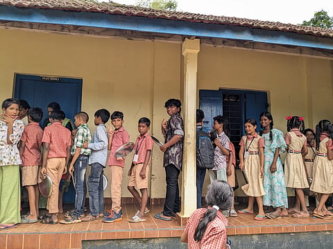 Children line up for lunch at the Binanipuram school on June 3