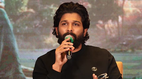 Actor Allu Arjun in a black full sleeved t shirt speaking into a mic 