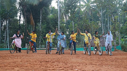 Eight women on cycles at one end of a playground