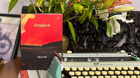 Short-story collection Sennilam with a brilliant red color cover by author Jeyarani placed against a  turquoise typewriter 
