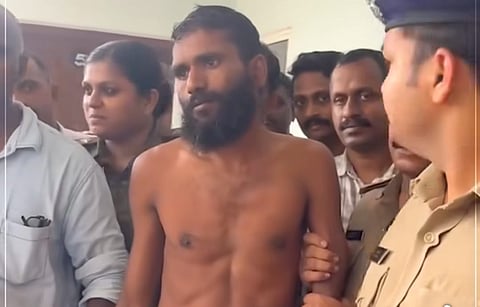 Govindachamy, shirtless and surrounded by police officers, is taken into custody following his escape from Kannur Central Jail in Kerala