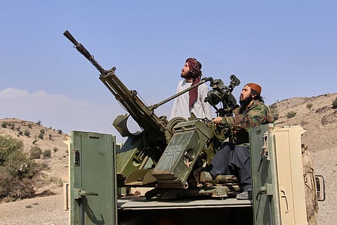 Taliban fighters look up while manning an armed pickup truck at the Afghan side of the Ghulam Khan crossing with Pakistan in Khost province, Afghanistan, Friday, Feb. 27, 2026. 