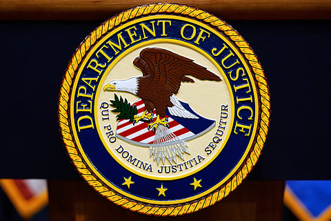 The U.S. Department of Justice logo is seen on a podium before a press conference, May 6, 2025, at the Justice Department in Washington. 