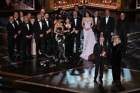 Paul Thomas Anderson, left center, Sara Murphy, right center, and the team from "One Battle After Another" accept the award for best picture during the Oscars on Sunday, March 15, 2026, at the Dolby Theatre in Los Angeles. 