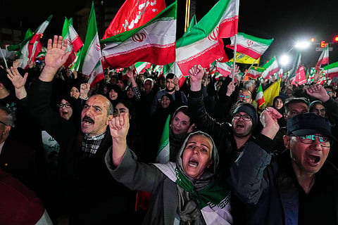 Pro-government supporters chant slogans and wave Iranian flags during a rally, in a square in western Tehran, Iran, Wednesday, March 25, 2026. 