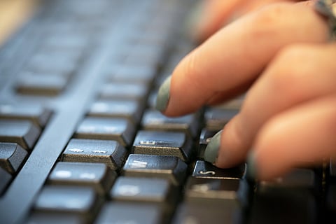A person types on a computer keyboard in New York, Oct. 8, 2019. 