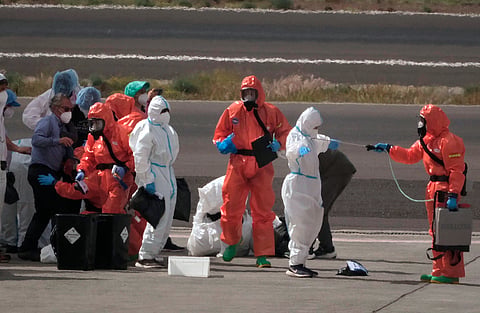 Passengers are sprayed with disinfectant by Spanish government officials before boarding a plane after disembarking from the hantavirus-stricken cruise ship MV Hondius at Tenerife airport in the Canary Islands, Spain, Sunday, May 10, 2026. 