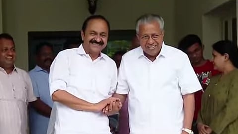 VD Satheeshan shakes hands with Pinarayi Vijayan. Both leaders in white shirts and mundus, smiling at the camera.