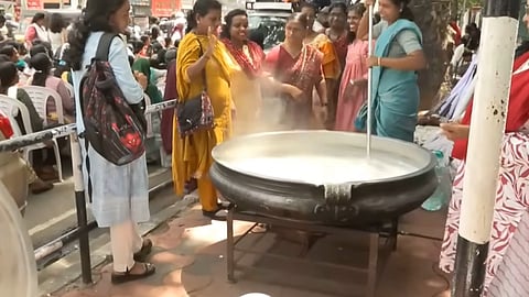 ASHA workers making payasam on a temporary stove arranged on the pavement in front of the Secretariat 