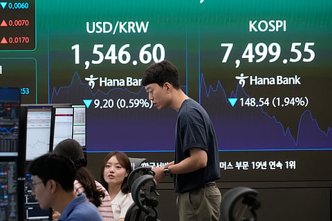 Currency traders work near a screen showing the Korea Composite Stock Price Index (KOSPI) and the foreign exchange rate between U.S. dollar and South Korean won at the foreign exchange dealing room of the Hana Bank headquarters in Seoul, South Korea, Friday, July 3, 2026. 