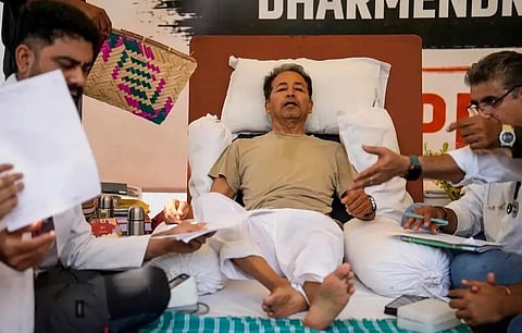 Sonam Wangchuk lies on a reclined bed at his hunger strike site at Delhi’s Jantar Mantar as doctors and volunteers attend to him during medical monitoring.