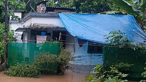 Image of a house, knee deep in water, during the floods.