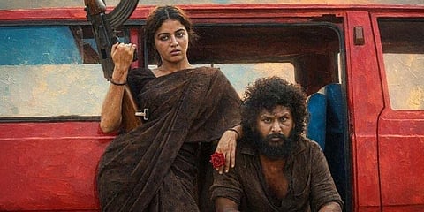 Wamiqa Gabbi and Lokesh Kanagaraj are in front of a red Omni van. He is sitting on the floor of the van with a pistol. She is standing with a rifle. Both are dressed in brown.  