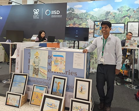 Johnson Jamnet, director of Blue Green Coastal Resources and a PhD scholar from Thiruvananthapuram’s fishing community, at a display of children’s paintings depicting traditional fishing practices and marine biodiversity at the 17th UN Conference of the Parties to the Convention on Biological Diversity (CBD COP17) in Yerevan, Armenia.