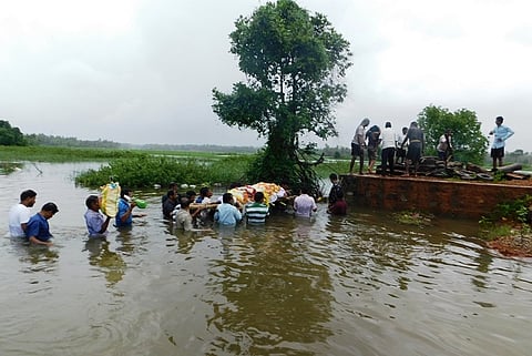 Residents of K'taka village brave chest-high water to cremate dead body