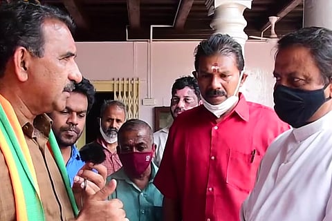A screenshot from the video where Ollur BJP candidate B Gopalakrishnan (left, in brown shirt) is appealing to a Christian priest to vote for the BJP. Other party members are seen standing around Gopalakrishnan and the priest.