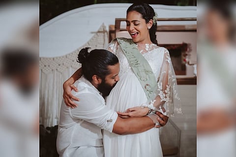 Balu Varghese is seen kissing wife Aileena's baby bump. Balu is seen in a white shirt while Aileena is seen in a white dress.
