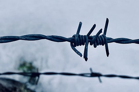 A barbed wire fence in a snowy field
