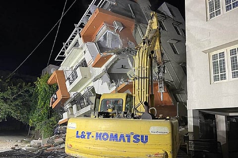 Earthmovers demolishing the building which collapsed on Thursday