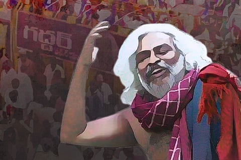 Gaddar, holding his hand up while singing, he is wearing a maroon shawl